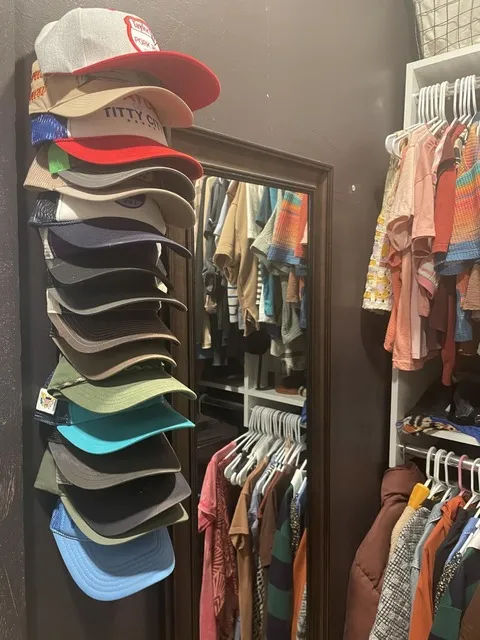 Cap organizer mounted beside a closet mirror