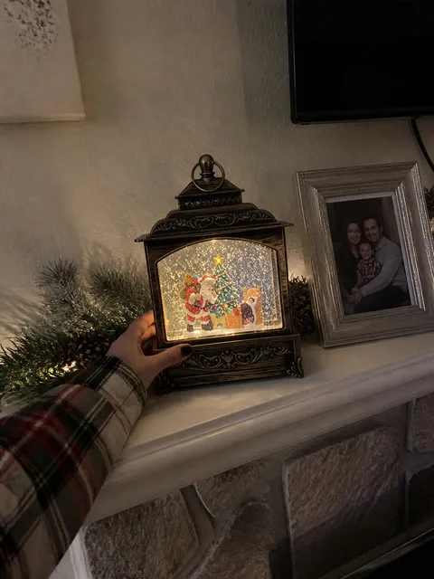 Christmas lantern being placed on a small apartment mantel
