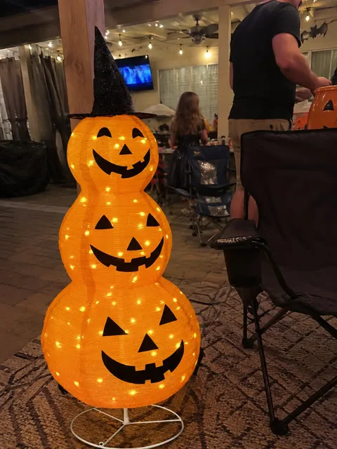Glowing stacked pumpkin lantern on a covered patio