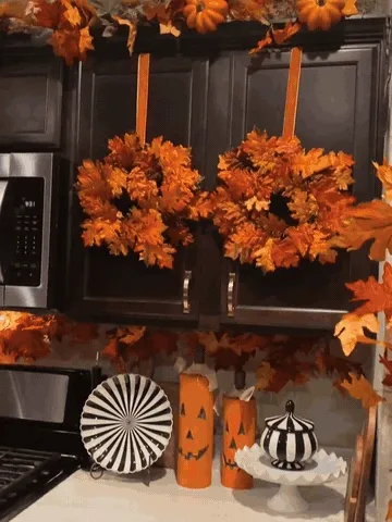 Mini fall wreath being positioned on a kitchen cabinet