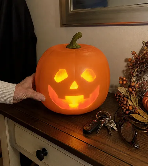 Animated pumpkin glowing on an entryway console beside keys and glasses