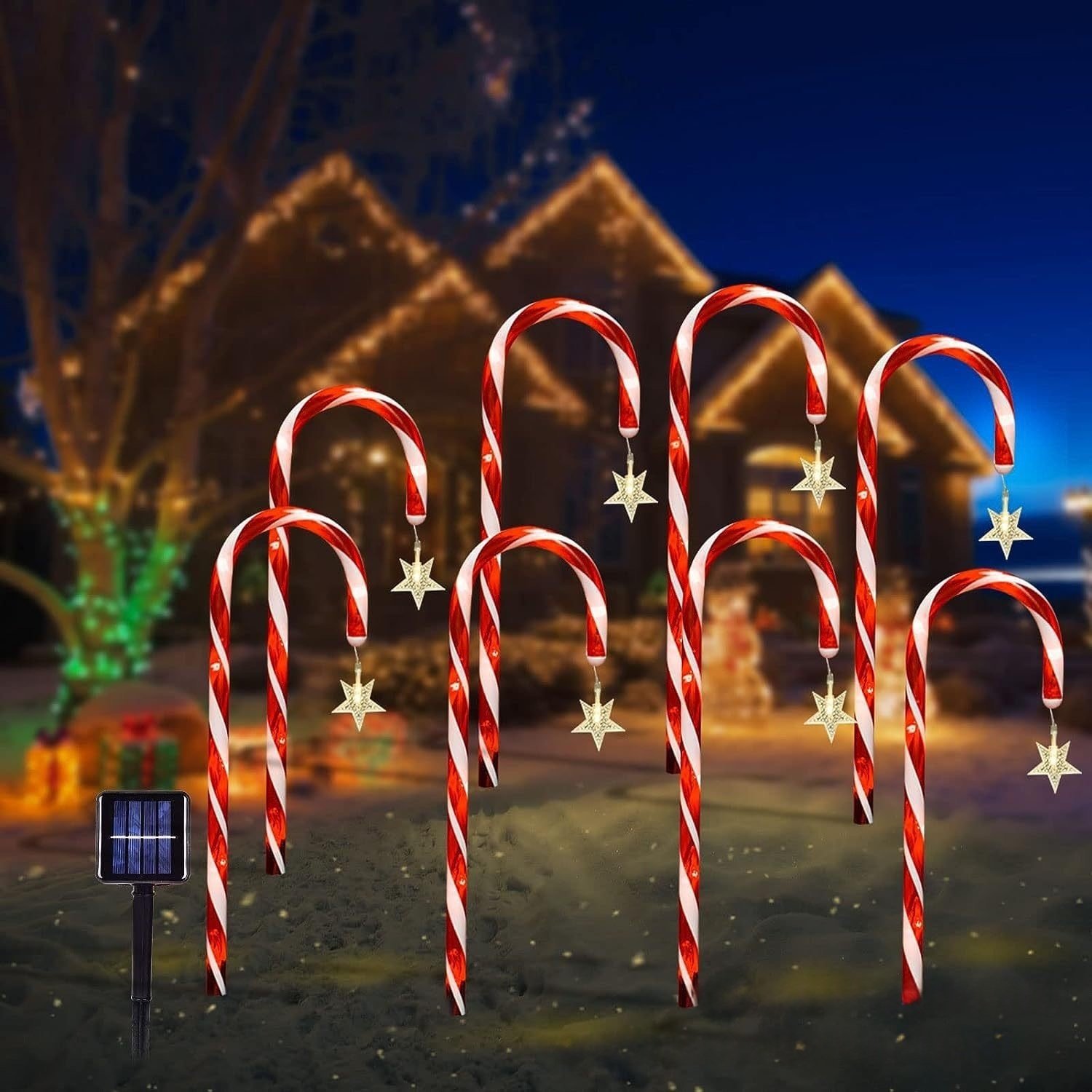 A set of candy cane lights glowing at dusk with a house in the background