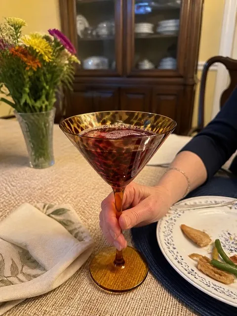 Amber tortoiseshell martini glass held during a cozy family dinner
