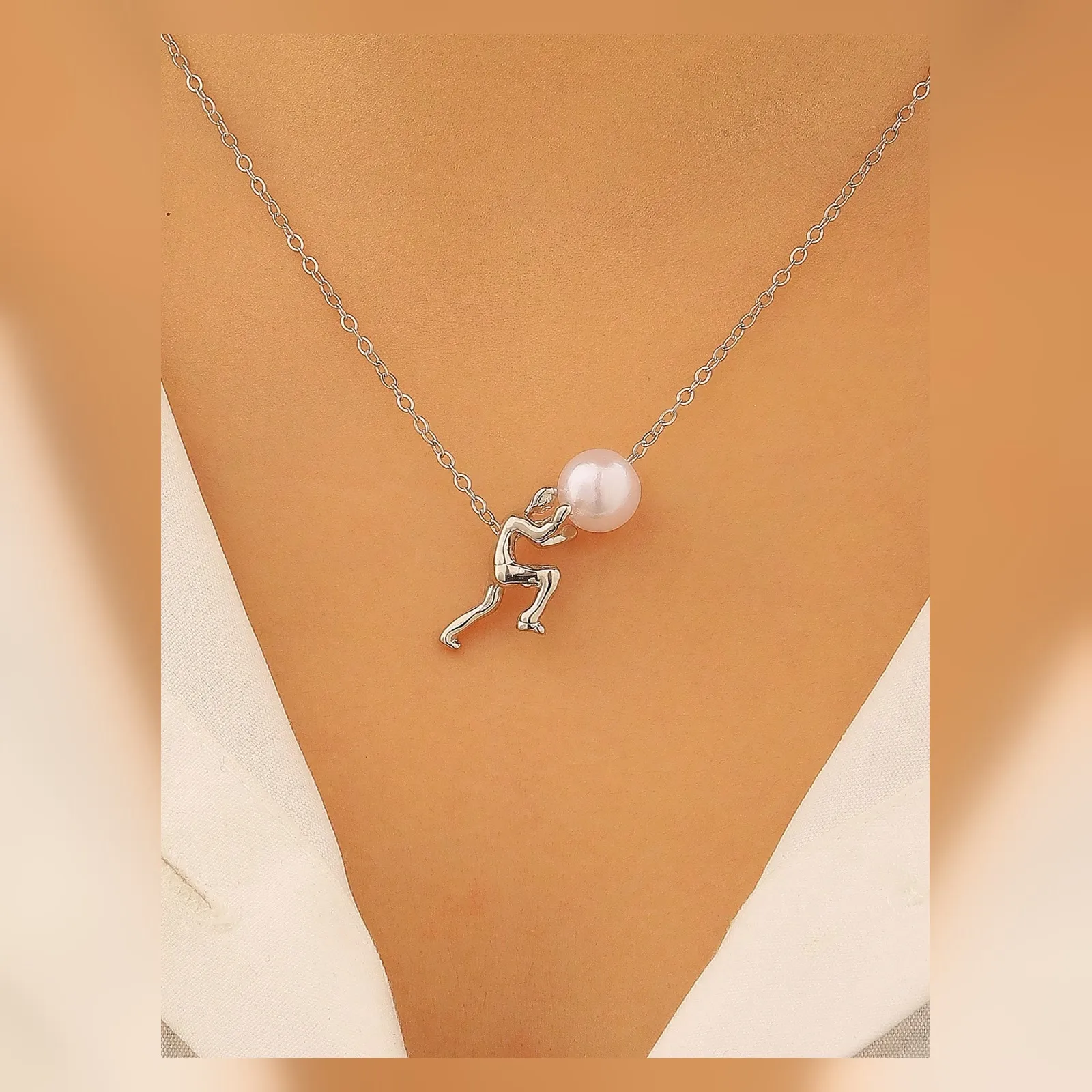 Silver-tone pearl pusher necklace worn at the neckline