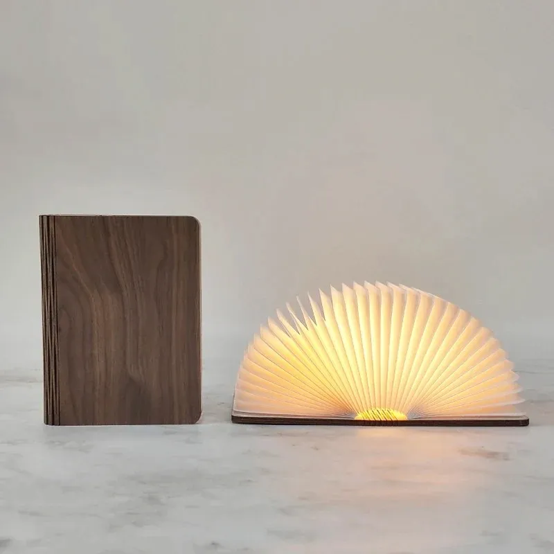 Walnut folding book light shown closed and opened into a glowing semicircle