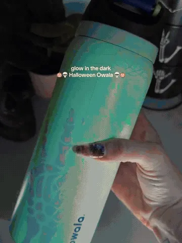 Bottle changing from a pale daytime finish to a vivid green glow and showing the flip lid