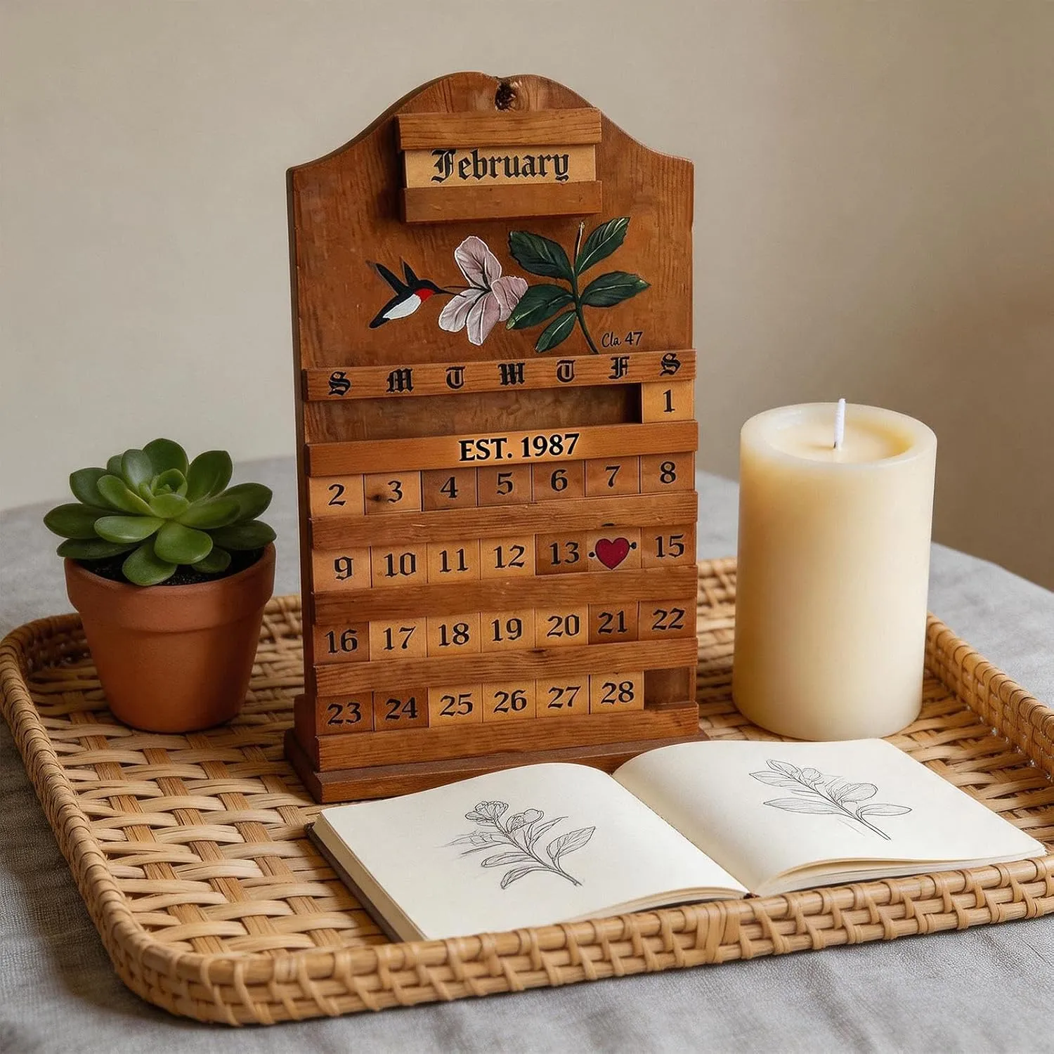 Wooden calendar styled with a plant, candle, and notebook