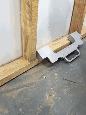 Framing jig positioning wall studs before fastening