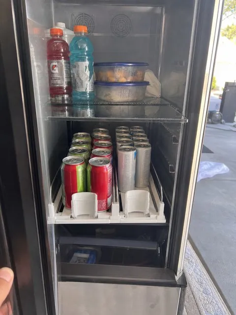 Two organized drink rows in a garage refrigerator