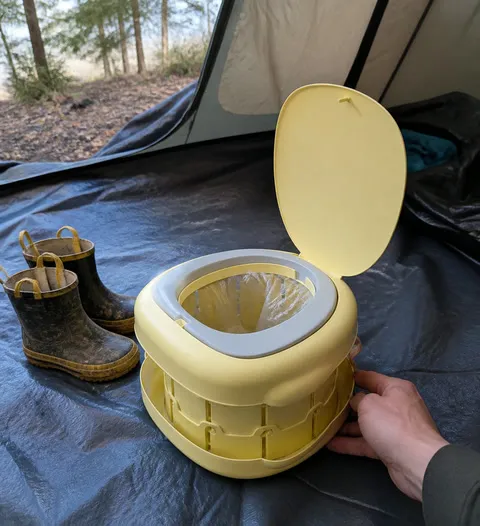 Portable kids potty prepared inside a family camping tent