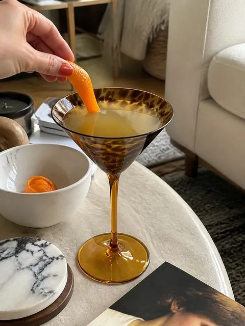 Amber tortoiseshell martini glass with a citrus drink on an apartment coffee table