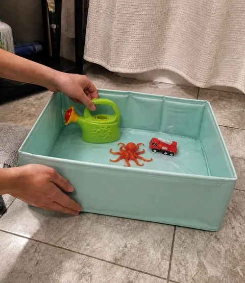 Bath play set arranged in the mint foldable basin in a home bathroom