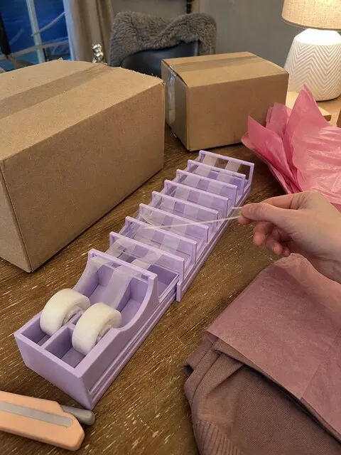 Purple tape strip dispenser at a small home packing station