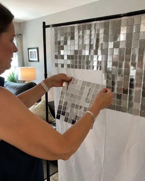 Woman assembling silver shimmer panels in a living room