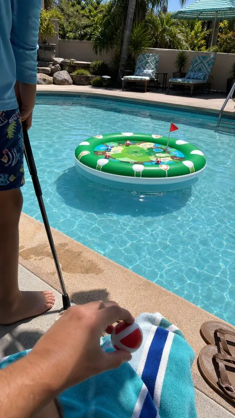 Child preparing a sticky ball beside a floating pool golf target