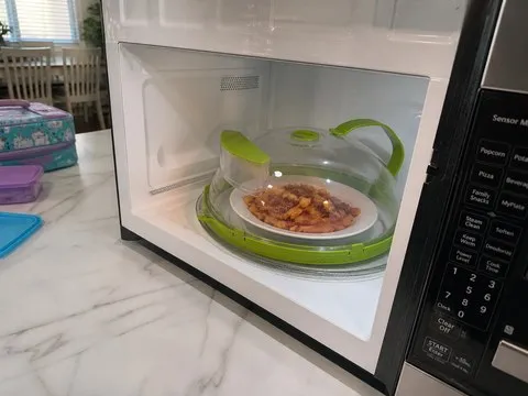 Covered pasta plate inside a family microwave