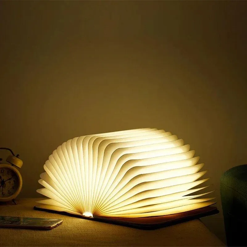 Warm book-shaped lamp on a quiet nightstand