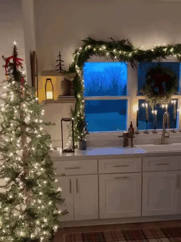 Warm white lights glowing through softly draped Norfolk-style pine garland
