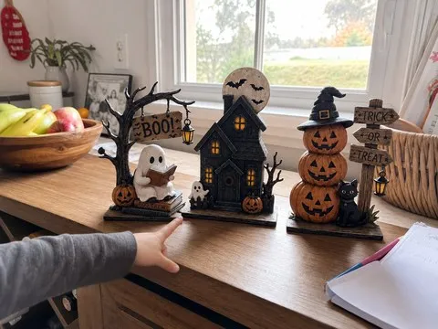 Child pointing to the reading ghost in a three-piece Halloween display