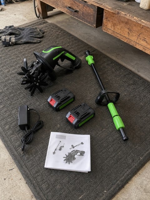 Cordless tiller kit with extension pole, two batteries, charger, and manual