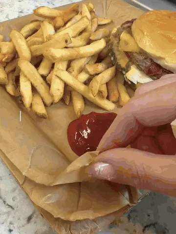 A full-size coated-paper layer peeling from the supporting square paper tray