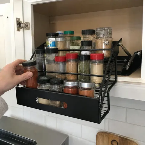 Black pull-down rack in a white home kitchen cabinet