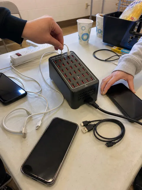 Phones charging at a neighborhood community event table