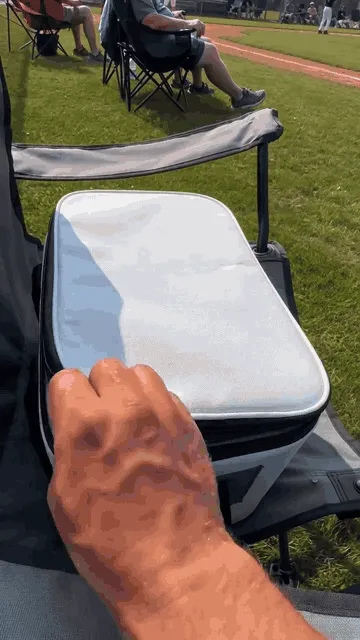 Baseball ice sphere being added to a cold drink at a ballpark