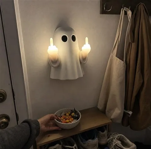 Cheeky ghost wall light glowing beside an everyday entryway