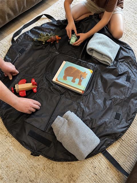 Black round organizer mat used for family trip packing Black round organizer mat used for family trip packing