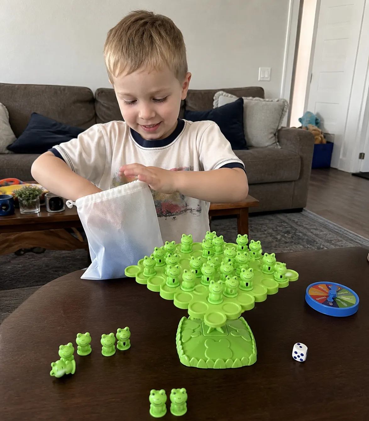 Child packing the frog balance game into its storage bag