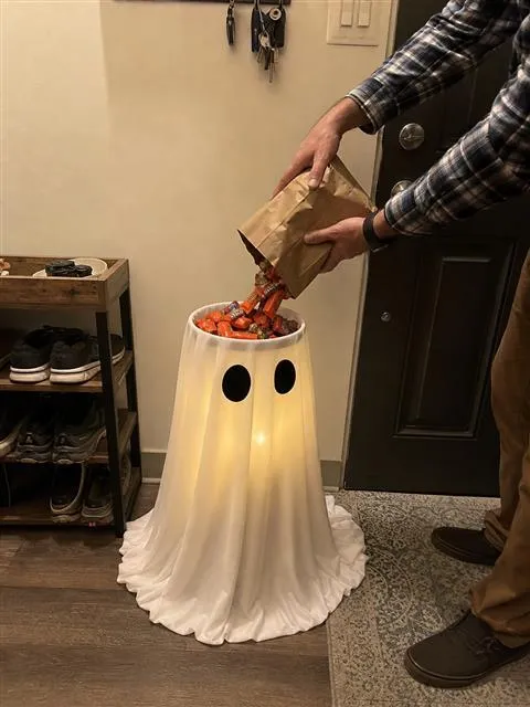 White glowing ghost candy bowl being filled in a home entry hall