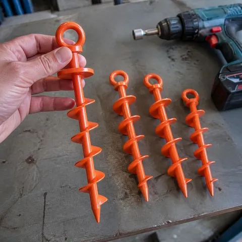 Four orange ground anchors ready for tool-assisted installation