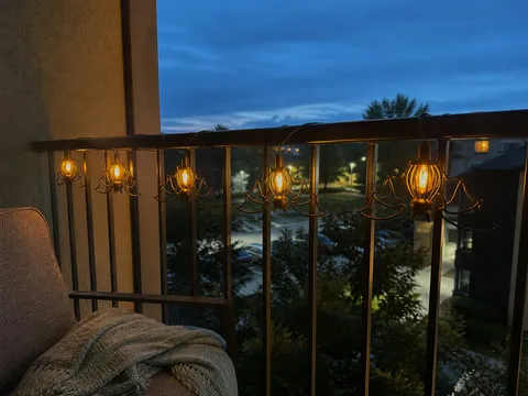 Bat string lights glowing along an apartment balcony