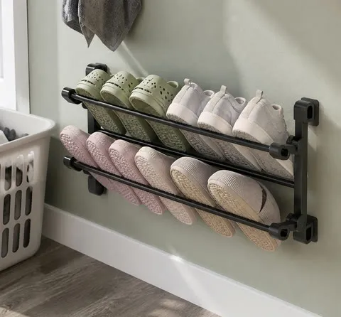 Wall shoe rack holding clogs near a laundry room entrance
