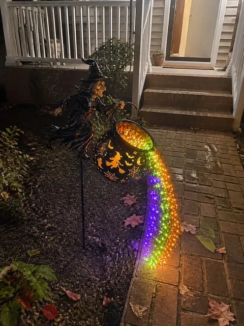 Witch cauldron light beside a brick walkway at night