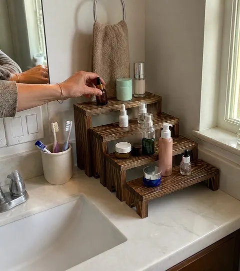 Wood risers organizing skincare on a small bathroom vanity