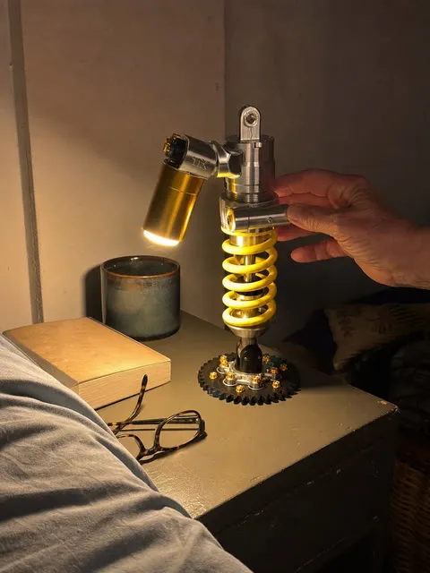 Shock absorber lamp casting a warm glow on a nightstand