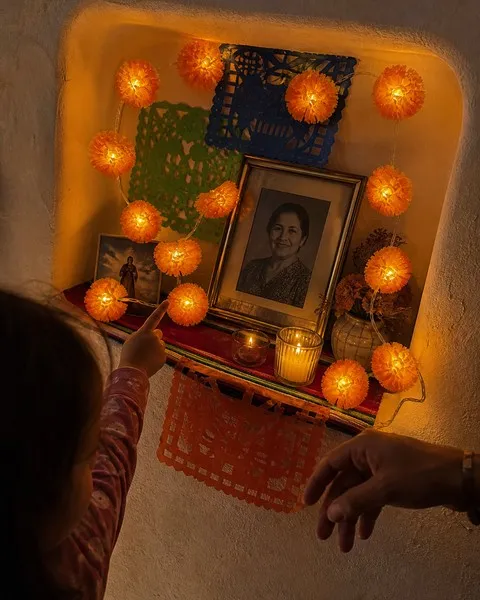 Family remembrance niche framed with glowing marigold flower lights