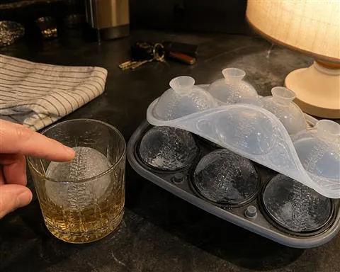 Baseball ice sphere in a home bar whiskey glass