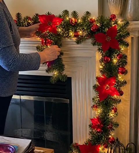 Garland being arranged on a home fireplace mantel