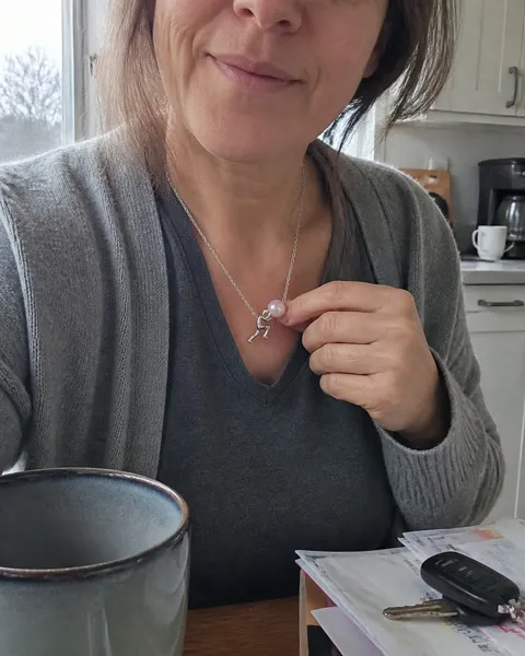 Silver-tone pearl pusher necklace in a casual kitchen photo