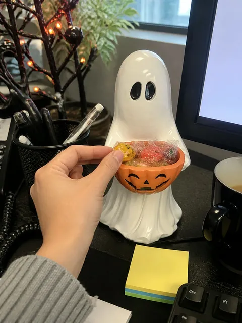 Ghost pumpkin bowl holding treats at an office desk