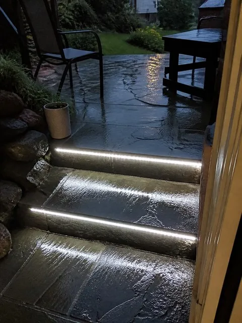 Strip lights glowing on wet patio steps