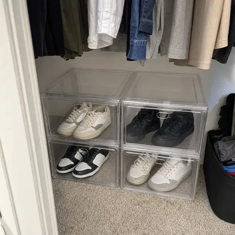 Clear side-opening shoe boxes organized in a closet