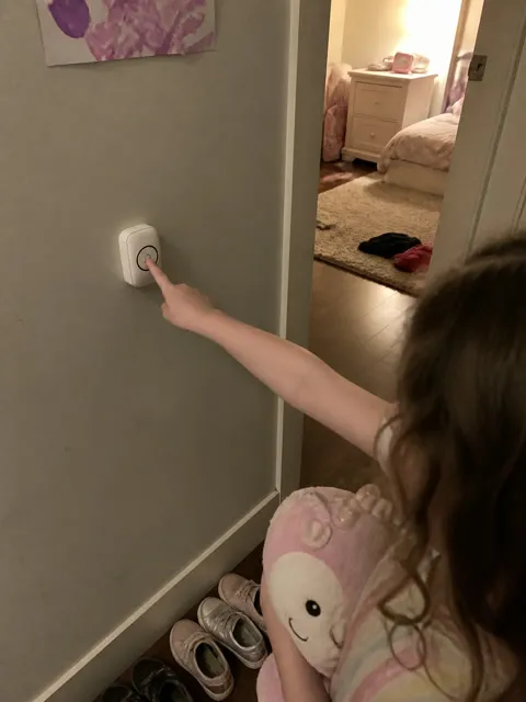 Child using a wireless call button near a bedroom