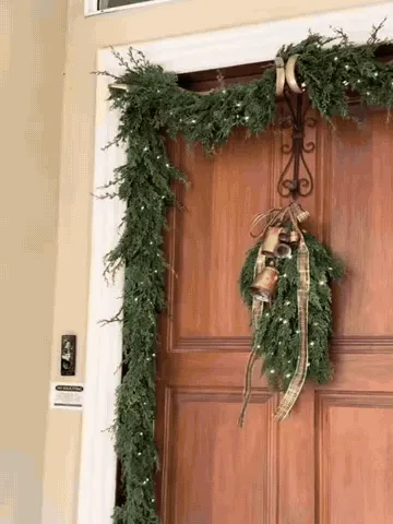 Garland being arranged across a front door with an adjustable wreath hanger