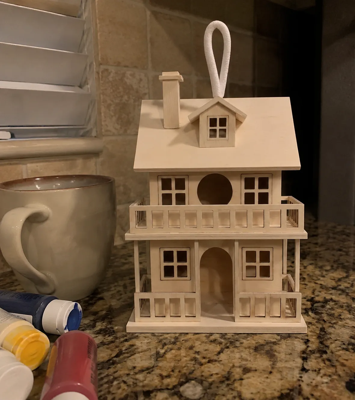 Natural wood birdhouse on a kitchen counter