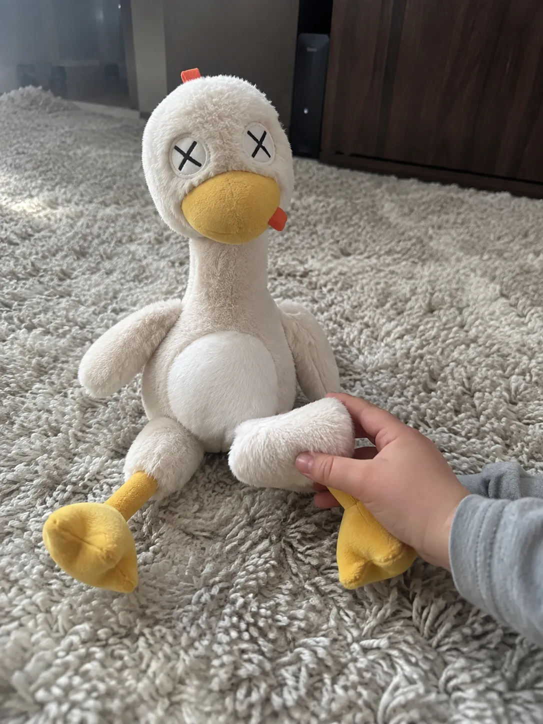 Child reconnecting the plush toy on a family-room rug