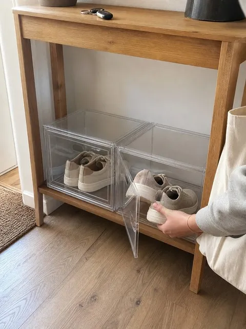 Clear shoe boxes under an entryway console